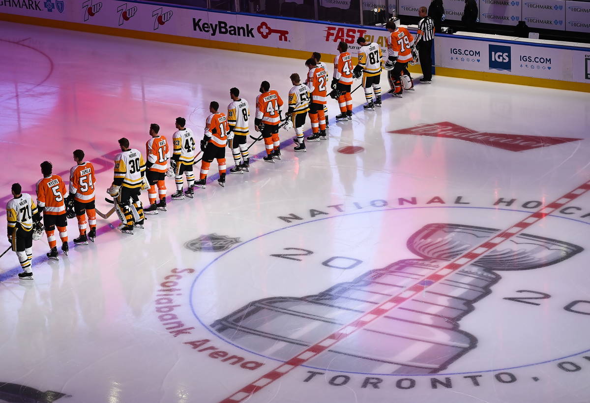 Los Pittsburgh Penguins y los Philadelphia Flyers se alinean para los himnos nacionales antes d ...