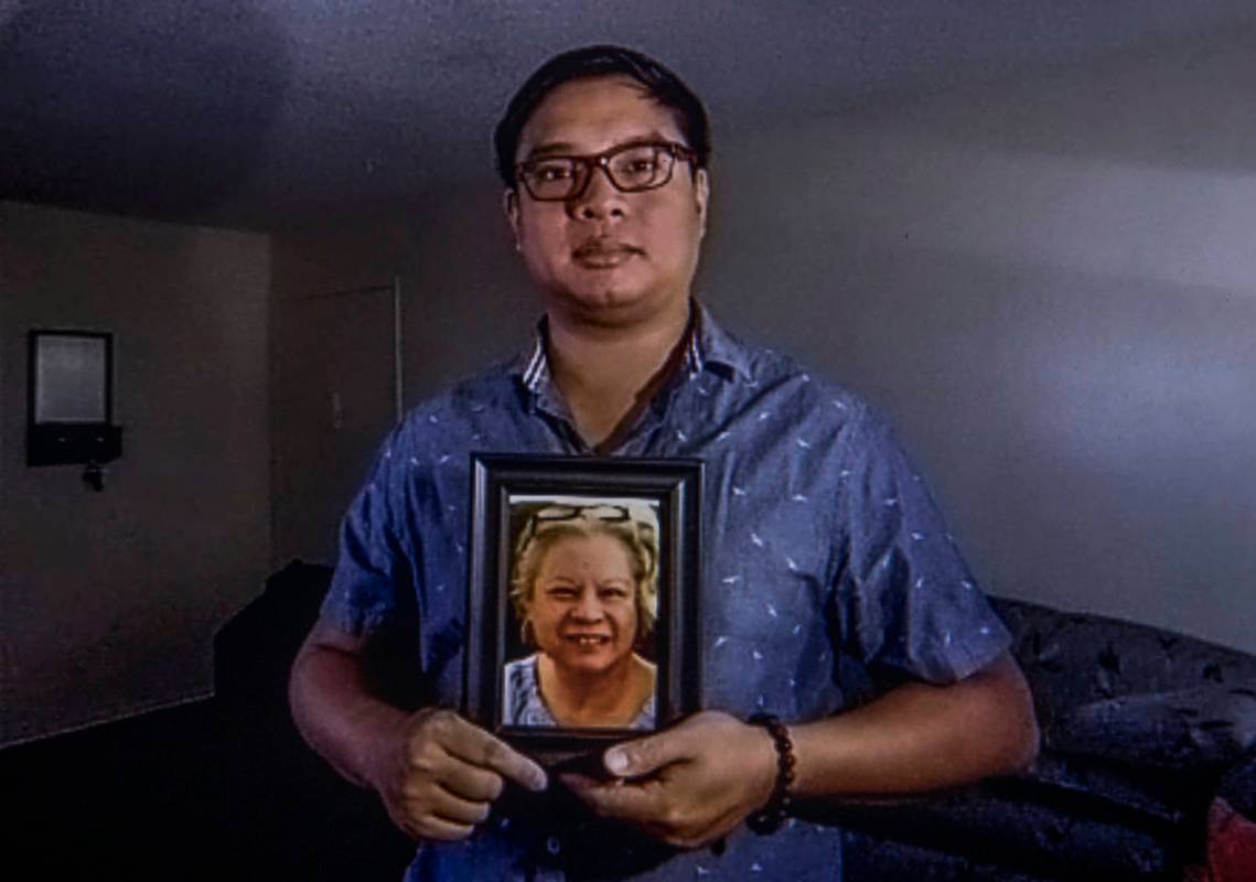 Roderick Alimusa sostiene una fotografía de su madre, María Alimusa, en su casa de Westminste ...