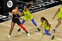 A'ja Wilson, de las Aces de Las Vegas, izquierda, observa para pasar el balón sobre Astou Ndou ...