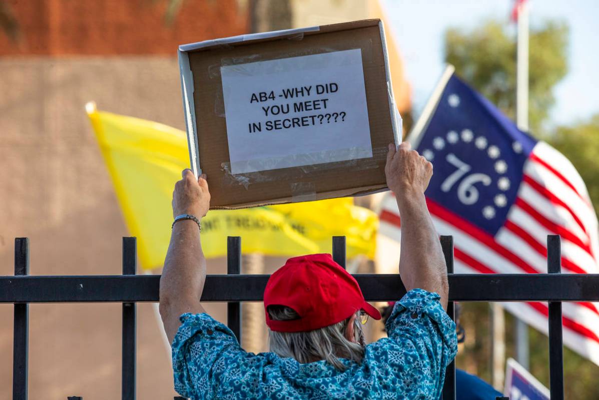 Un manifestante con un letrero frente al edificio Grant Sawyer para expresar su oposición a la ...