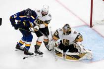 Zach Sanford (12) y Shea Theodore (27) luchan al frente mientras el portero Marc-Andre Fleury ( ...