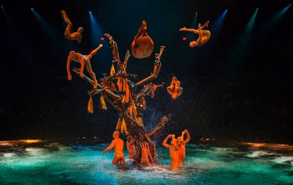Actores saltan al agua desde una gran estructura de árbol durante la presentación a las 7:00 ...