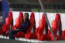El entrenador en jefe del Barcelona, Quique Setien, se sienta en el banco antes del inicio de l ...