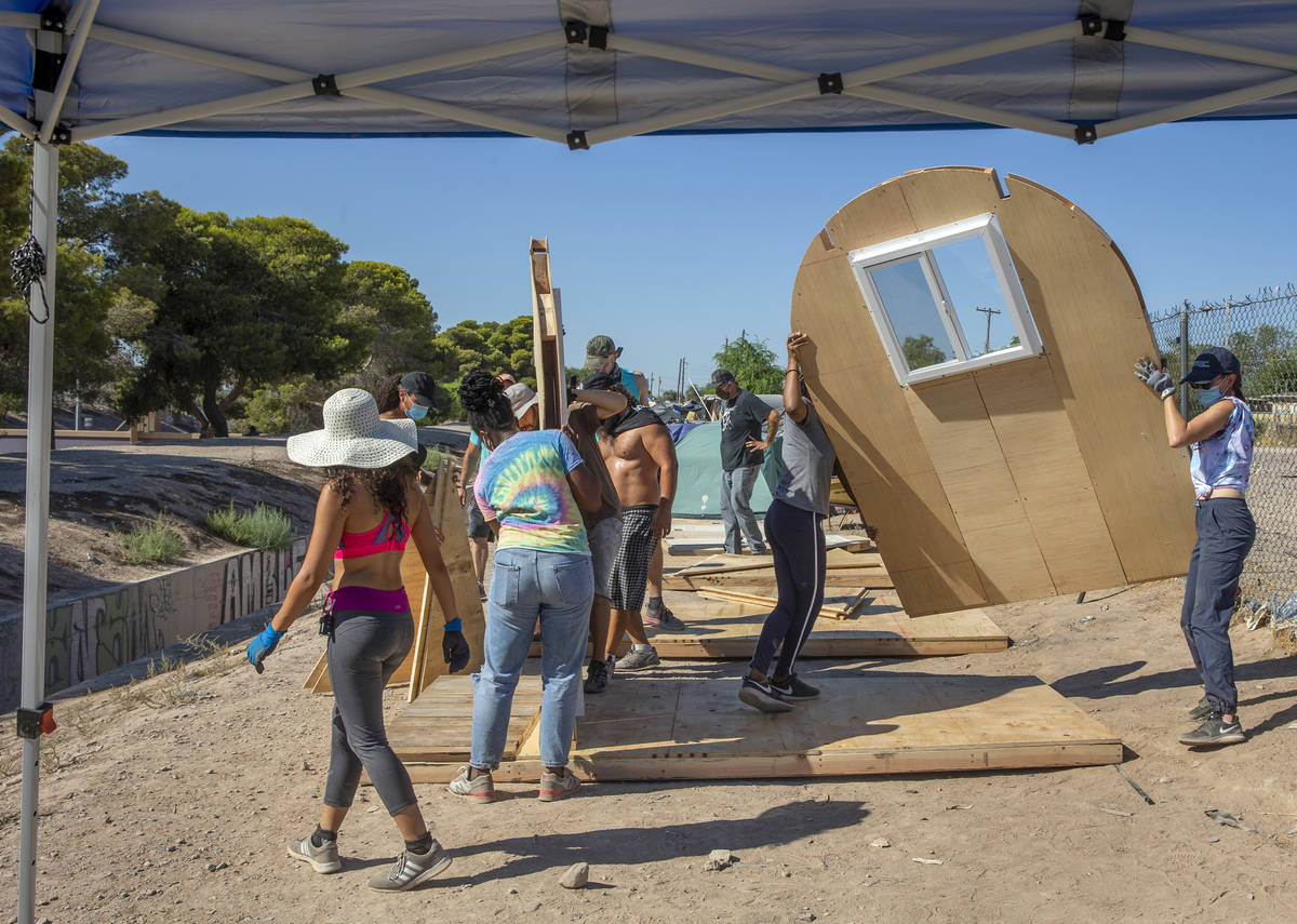 Miembros de "Food Not Bombs" y del "Sidewalk Project" colocan piezas prefabricadas para constru ...