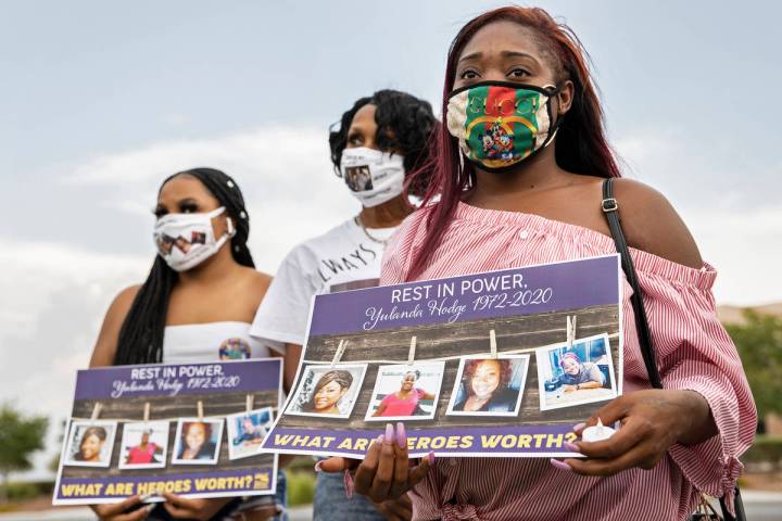 Dejanae Brown, de 23 años, hija de la trabajadora de salud Yulanda Hodge, escucha a un orador ...