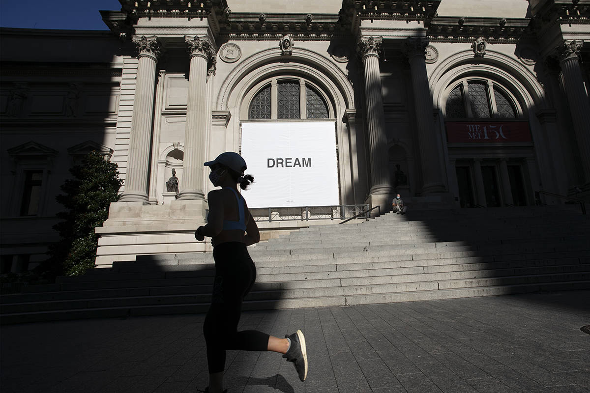 Una mujer pasa junto a una pancarta del artista Yoko Ono en el Museo Metropolitano de Arte, el ...