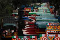 Gondoleros poseen trajineras, botes de madera pintados de colores populares entre turistas y ju ...
