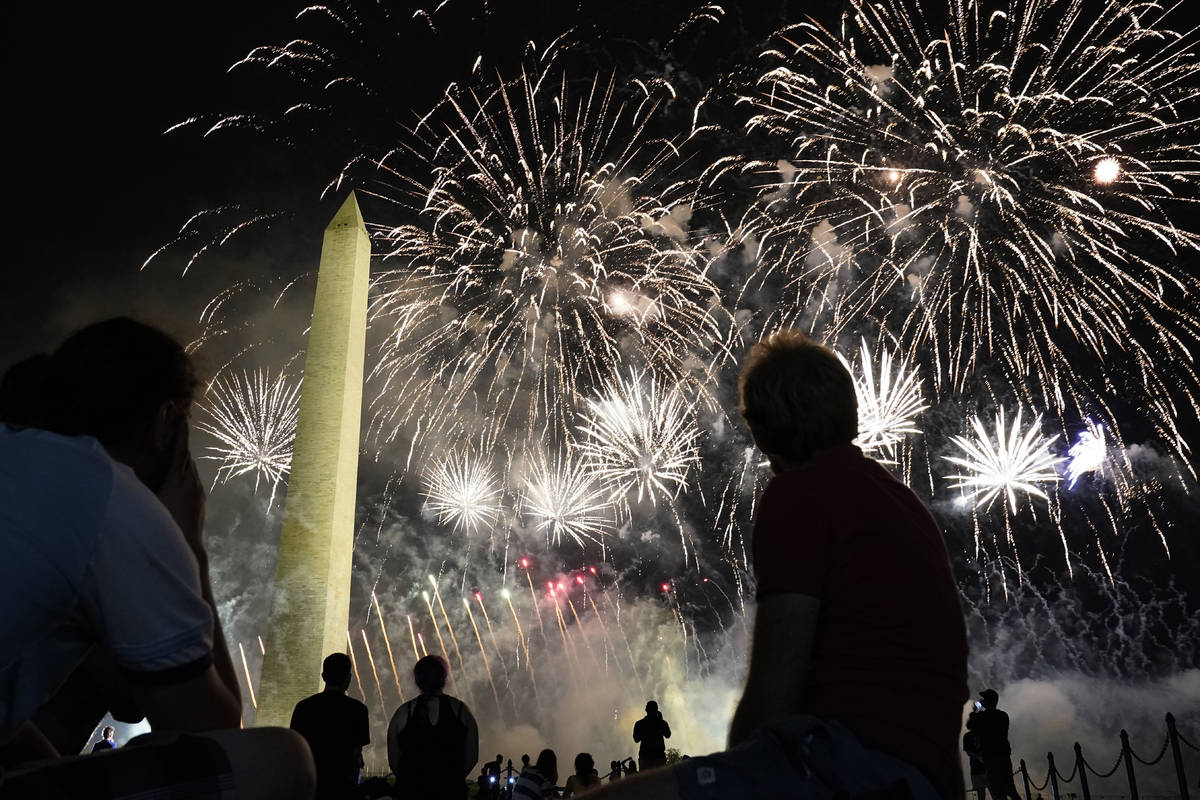 Fuegos artificiales iluminan el cielo alrededor del Monumento a Washington después de que el p ...