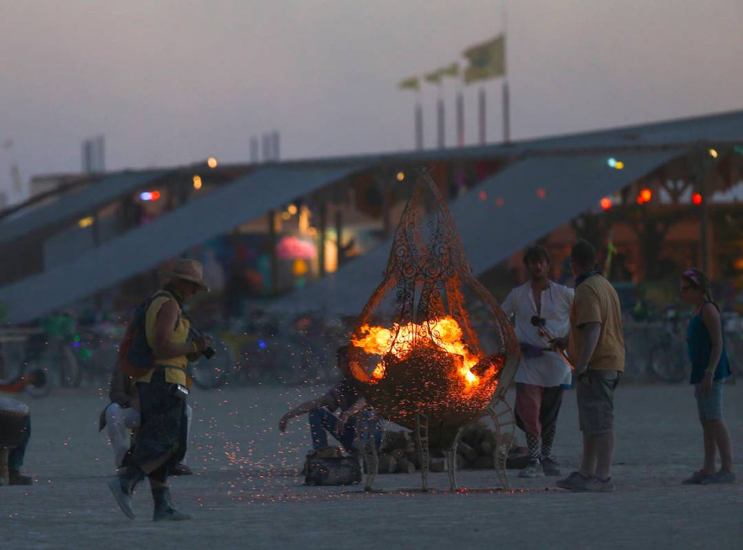 Los asistentes se reúnen alrededor de un foso de fuego durante Burning Man en el desierto de B ...