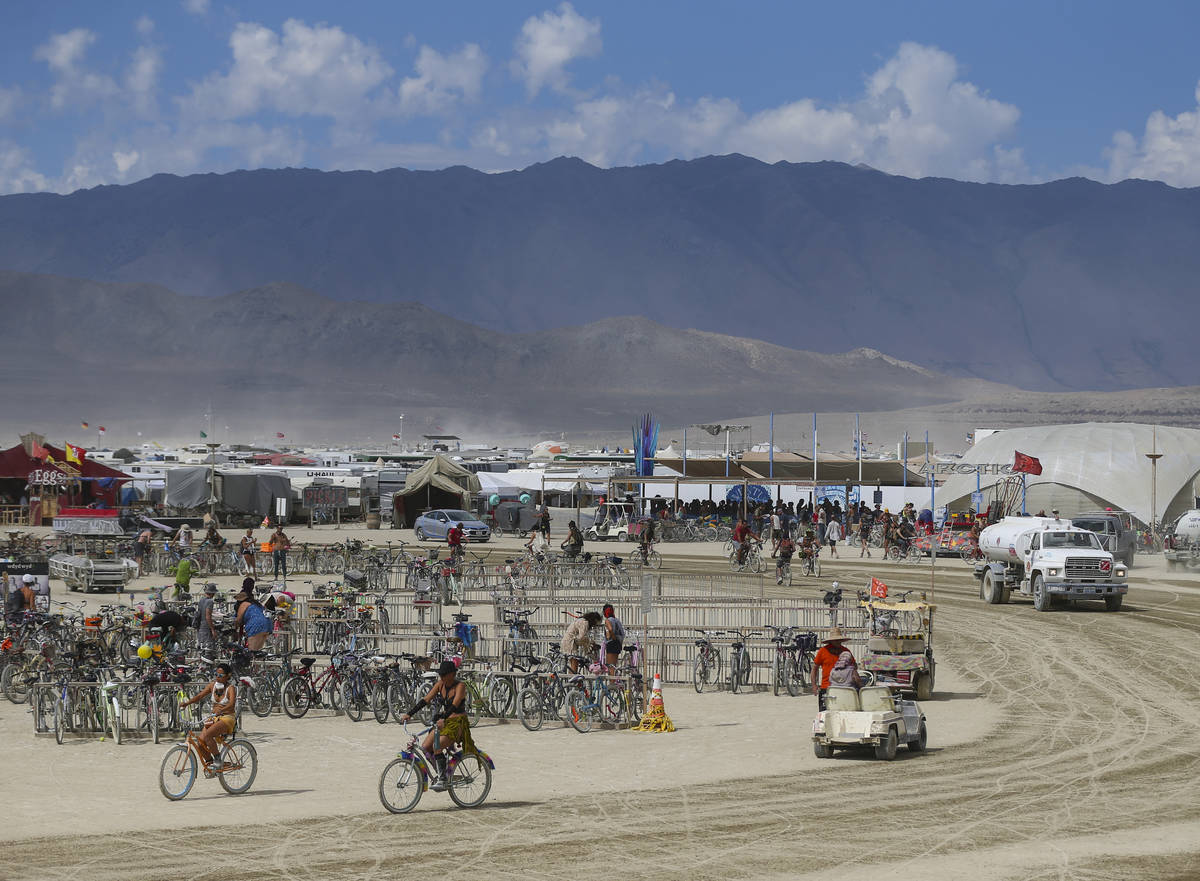 Los asistentes pasan por el área del campamento central durante Burning Man en el desierto de ...