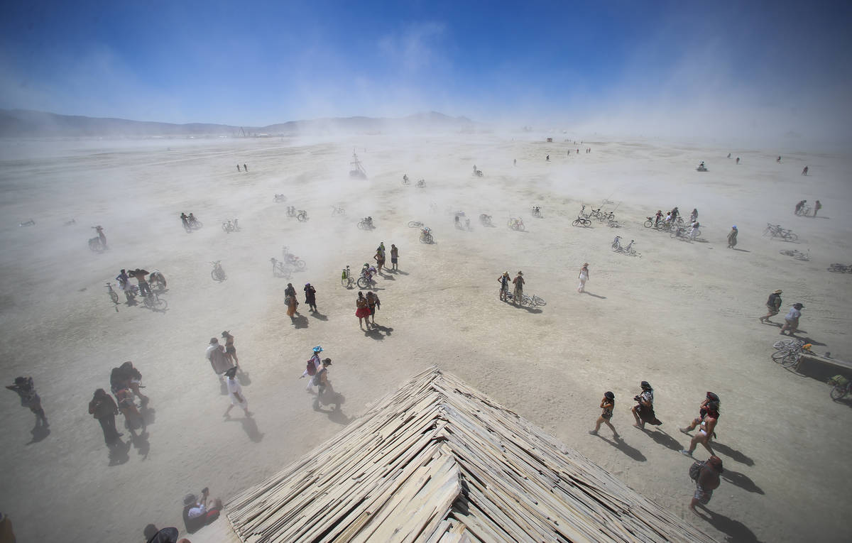 Los asistentes pasan por el área del campamento central durante Burning Man en el desierto de ...