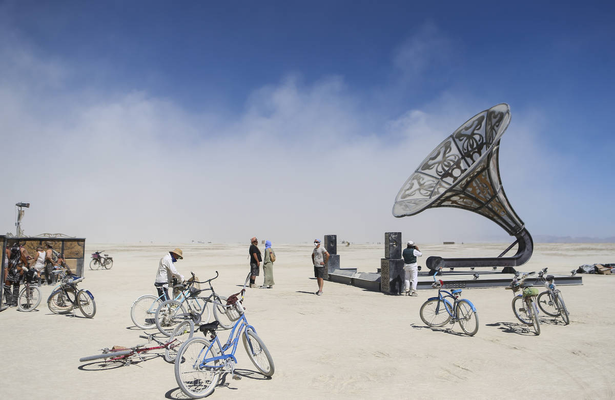 Los asistentes pasan por el área del campamento central durante Burning Man en el desierto de ...