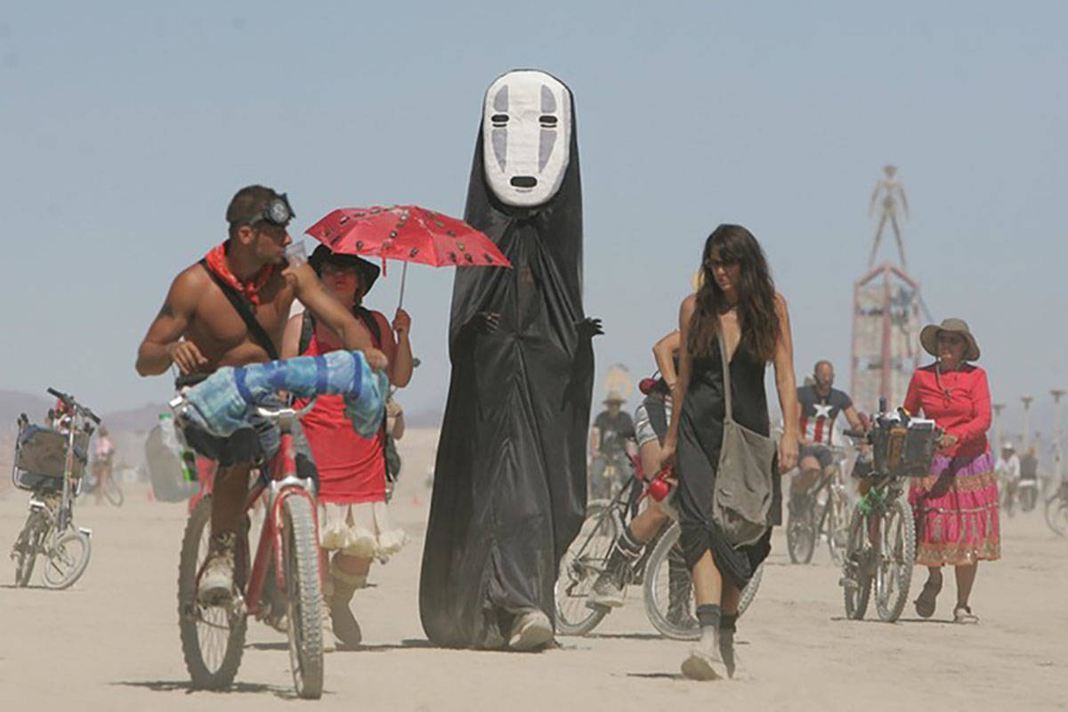 Participantes del Burning Man caminan en la playa del desierto de Black Rock cerca de Gerlach e ...
