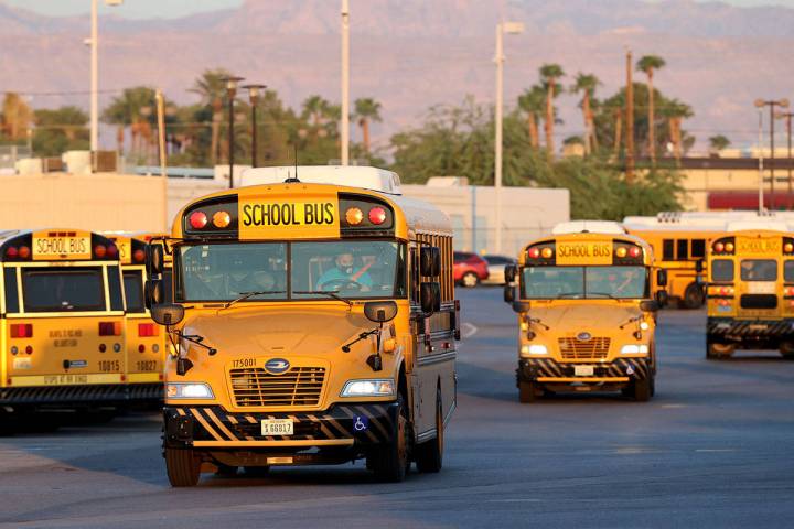 Conductores se dirigen al patio de autobuses de Arville del Distrito Escolar del Condado Clark ...