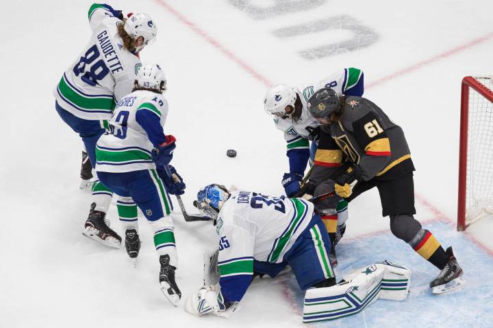 El portero de los Canucks de Vancouver, Thatcher Demko (35), hace una atajada mientras los juga ...