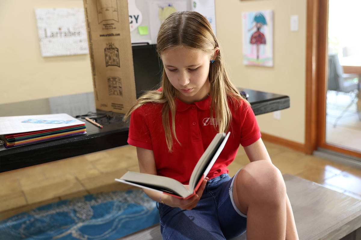 Lily Larrabee, de 10 años, estudiante de Legacy Traditional School, lee un libro después de t ...