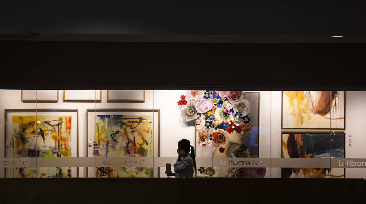 Una mujer ajusta su cubrebocas mientras visita Leftbank Art showroom durante Summer Las Vegas M ...