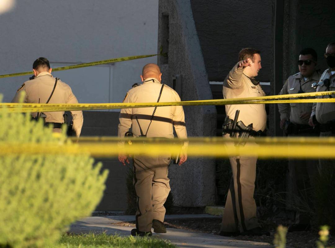 Oficiales hacen guardia fuera de la escena de una investigación de homicidio en los apartament ...