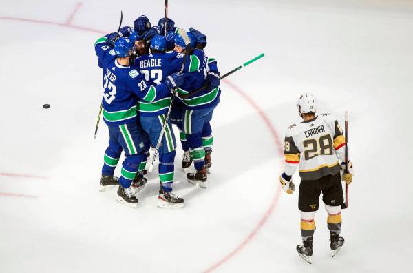 Los jugadores de los Vancouver Canucks celebran un gol del primer tiempo del sexto juego de la ...