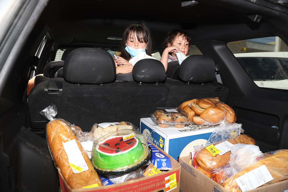 Zamira, de cinco años, y su hermana Zeriah Basulto de Las Vegas, miran la comida que su famili ...