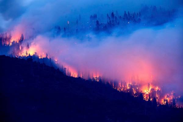 El Creek Fire arde a lo largo de una ladera en la comunidad de Cascadel Woods del Condado Mader ...