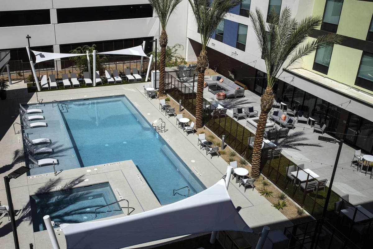 Una piscina vista desde un hotel Hampton Inn & Suites y Home2 Suites de doble marca, recienteme ...