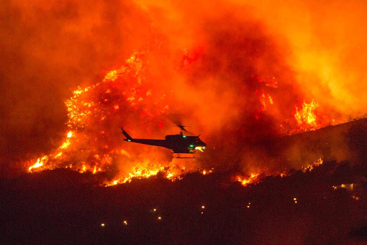 Un helicóptero se prepara para arrojar agua en un incendio forestal en Yucaipa, California, el ...
