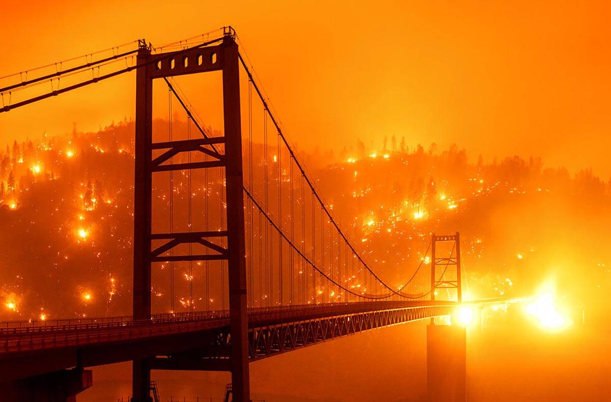 Las llamas se disparan desde un puente mientras el fuego del Bear Fire arde a través del área ...
