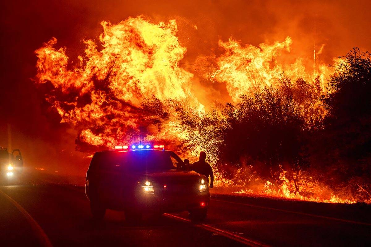 Las llamas pasan por los vehículos de la Autopista 162 mientras el Bear Fire arde en Oroville, ...