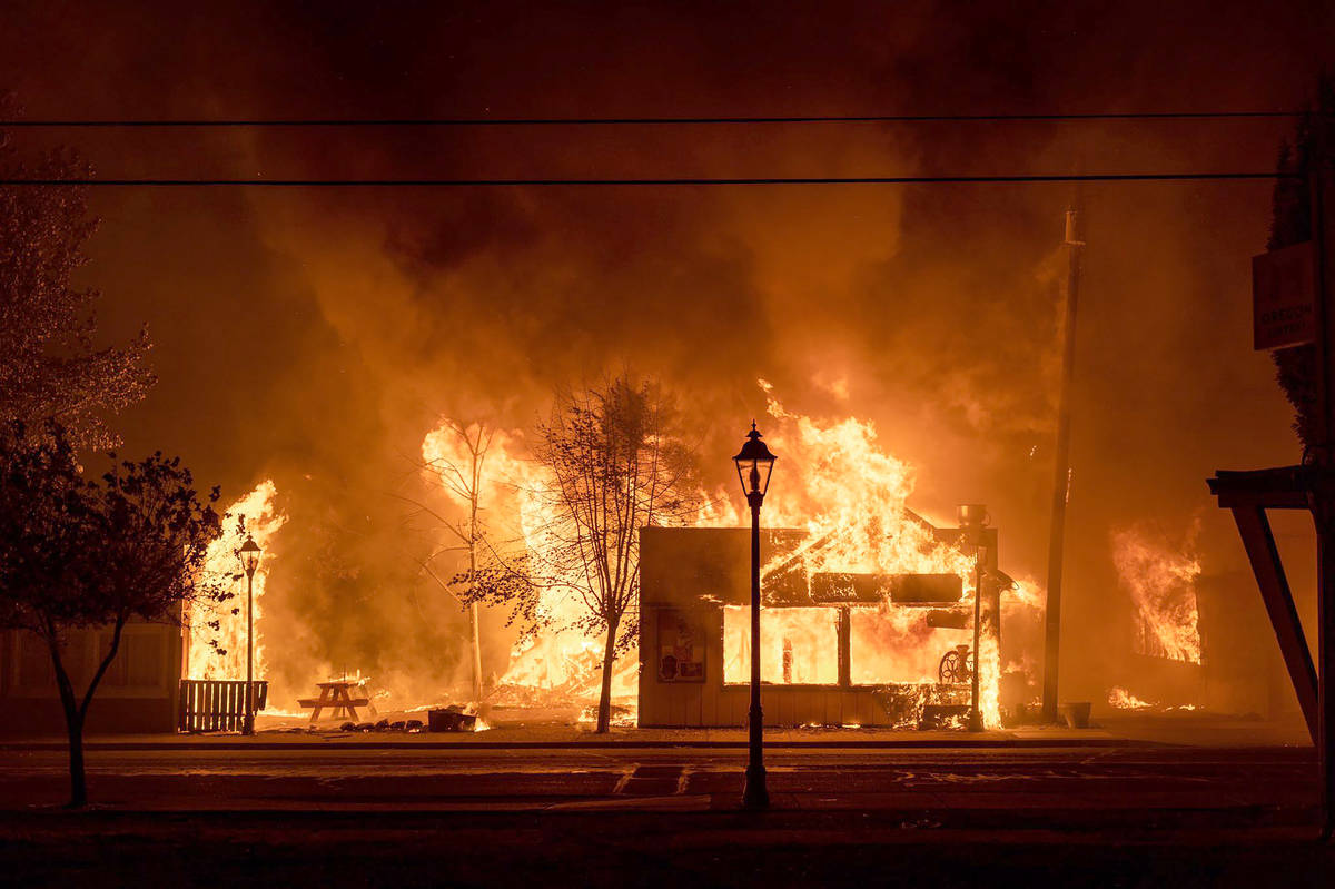 Los edificios están envueltos en llamas mientras un incendio forestal asola la ciudad de Talen ...