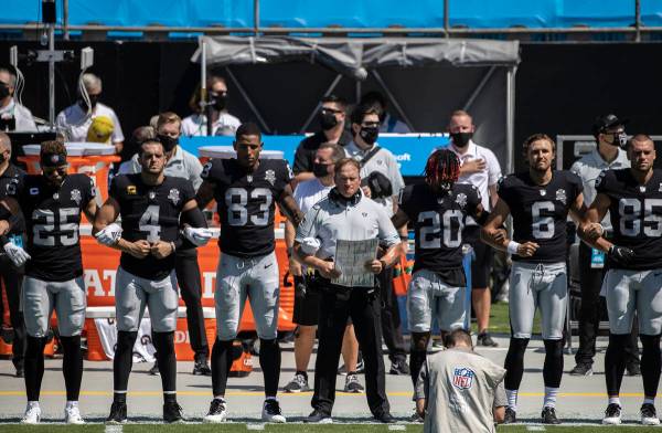 El entrenador de los Raiders de Las Vegas, John Gruden, al centro, se cruza de brazos con sus j ...