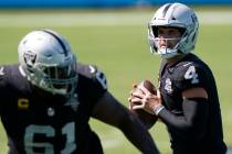 El mariscal de campo de los Raiders de Las Vegas, Derek Carr, busca pasar el balón durante la ...