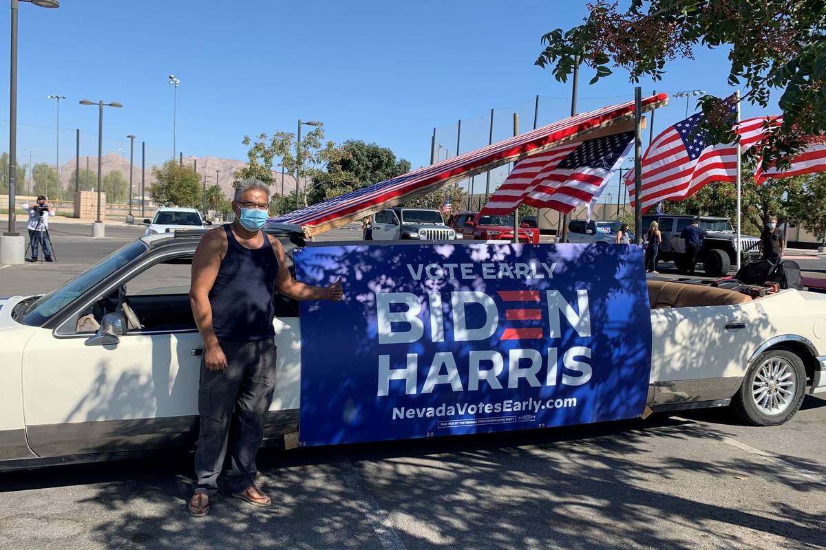 Eddie Ramos posa frente a su vieja limusina, que cubrió con carteles y banderas estadounidense ...