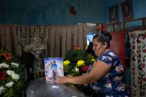 Una mujer coloca una foto del periodista asesinado Julio Valdivia en su ataúd durante un velor ...