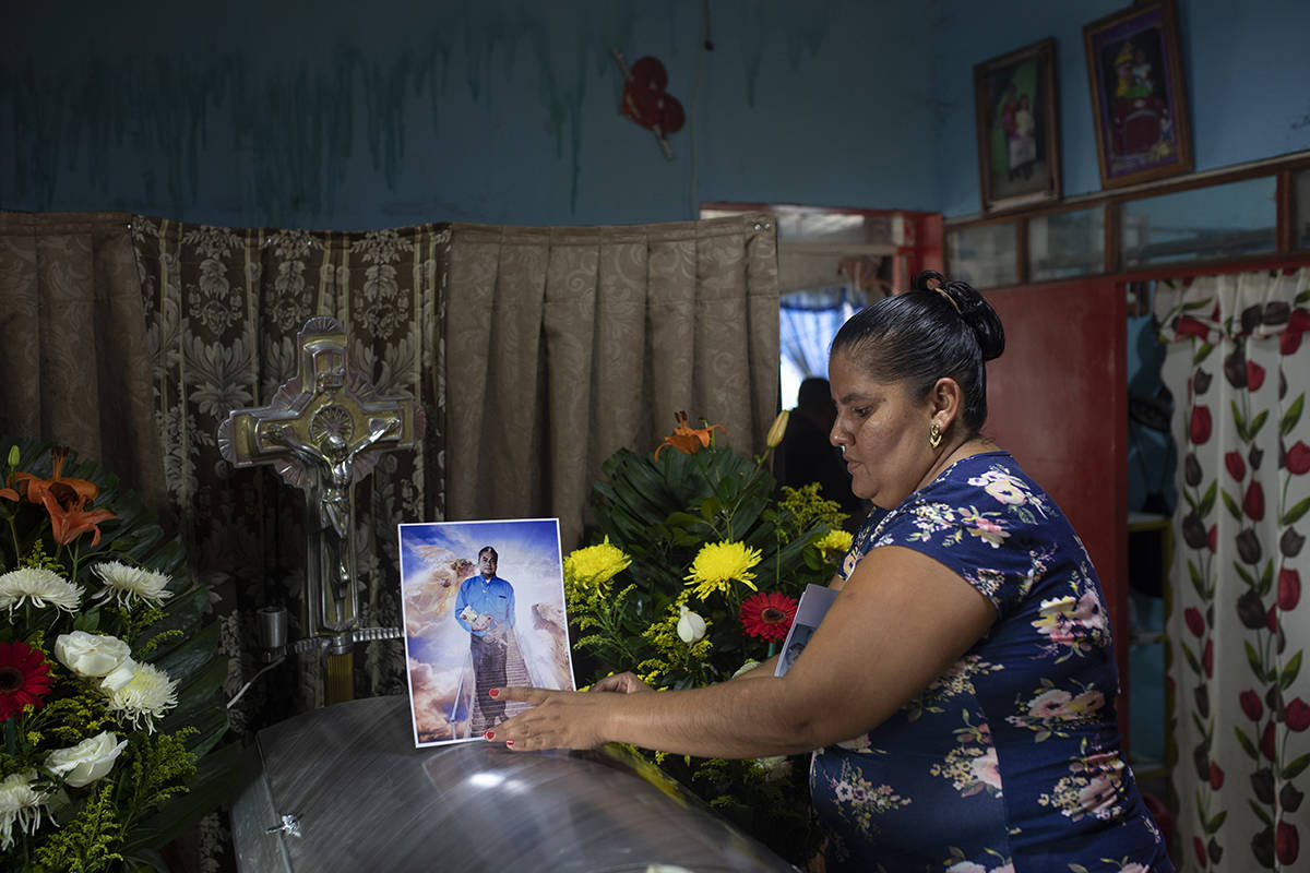 Una mujer coloca una foto del periodista asesinado Julio Valdivia en su ataúd durante un velor ...