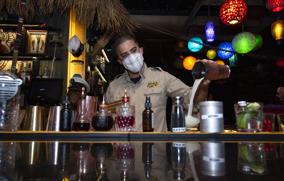 El bartender Jason Reyes prepara un cóctel tiki la primera noche que los bares reabrieron desd ...