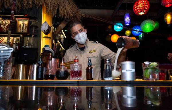 El bartender Jason Reyes prepara un cóctel tiki la primera noche que los bares reabrieron desd ...