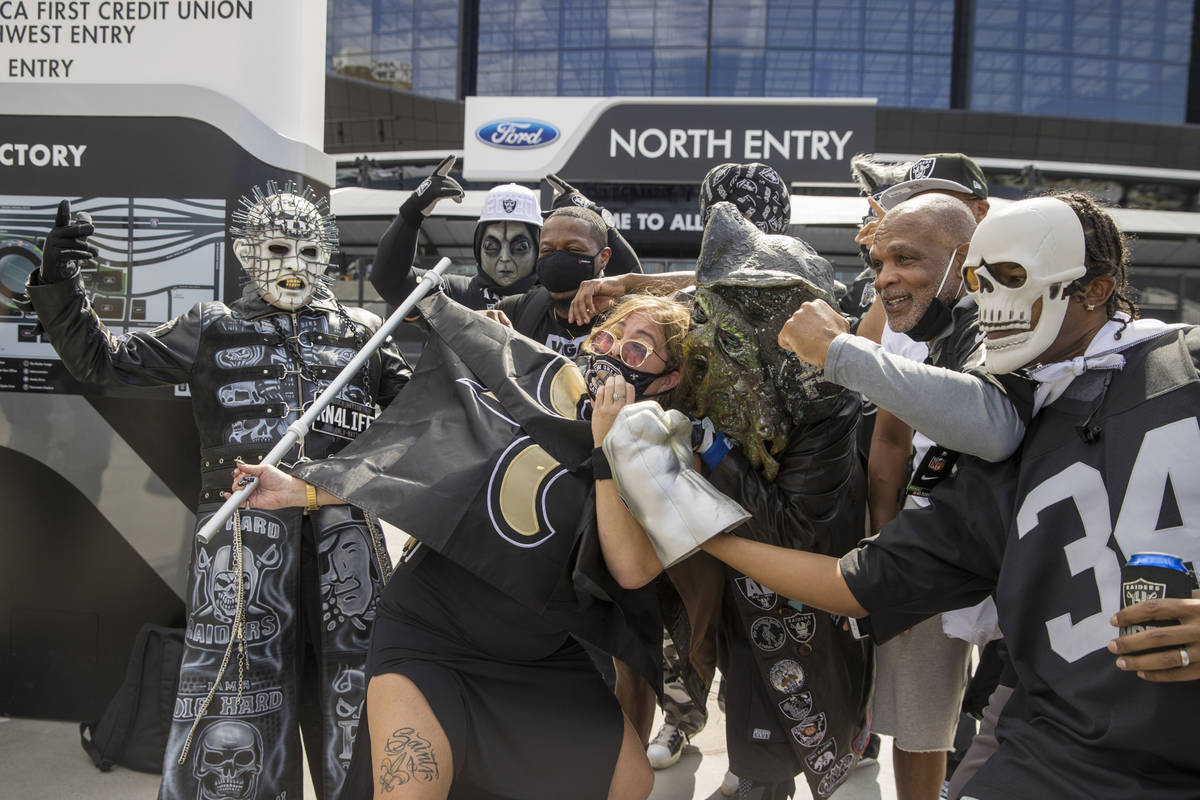 La fan de los New Orleans Saints, Amy Laughlin, rodeada por personajes de Los Raiders de Las Ve ...