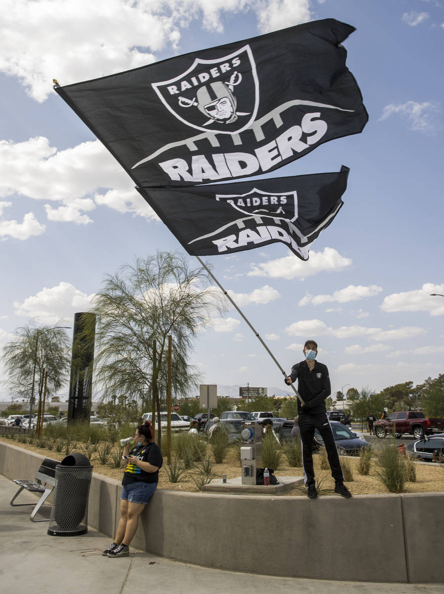 El fan de los Raiders de Las Vegas, Matt Helfst, ondea una bandera gigante mientras él y otros ...