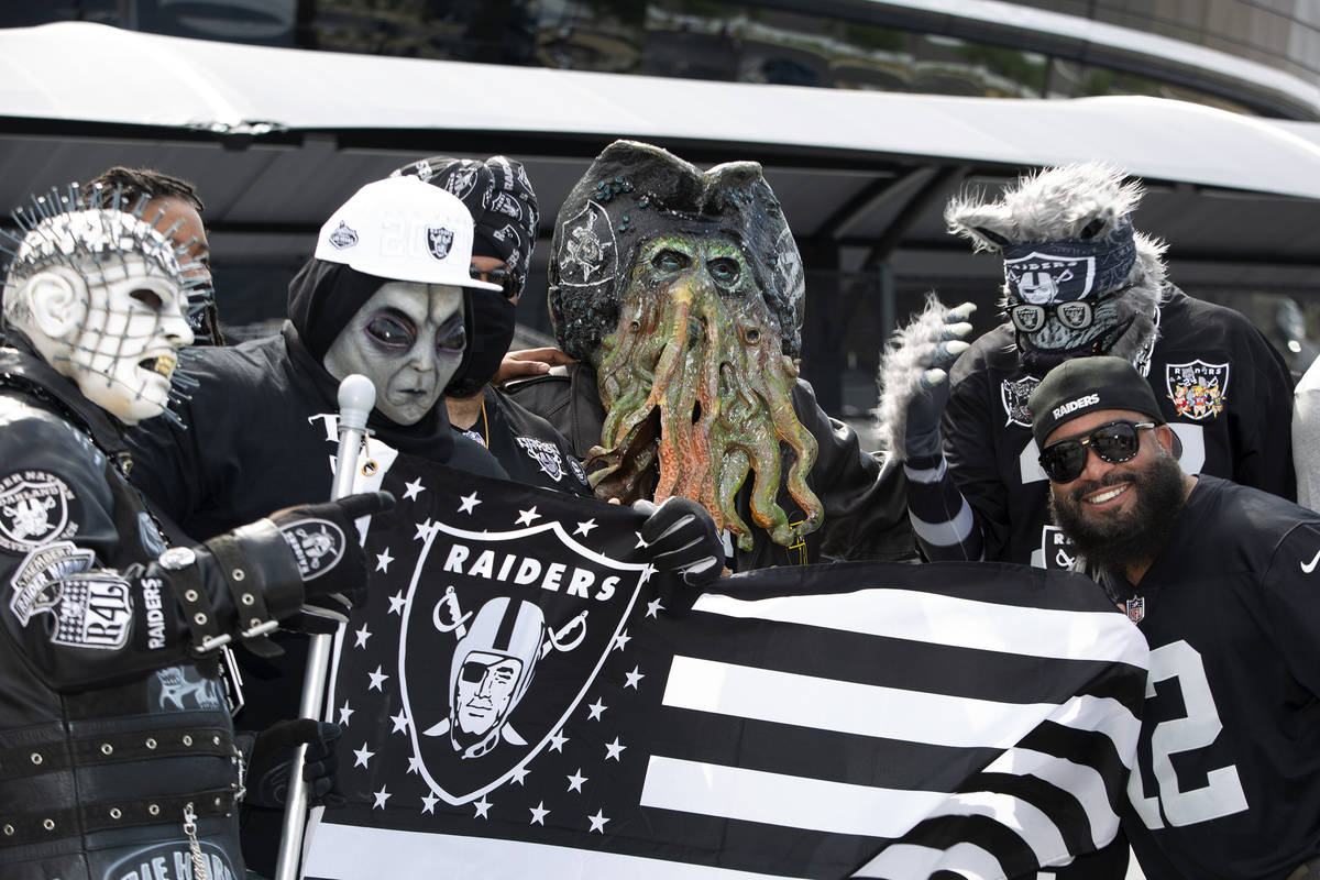Patrick Beckett de Nueva Jersey posa para una foto con fans de los Raiders disfrazados mientras ...