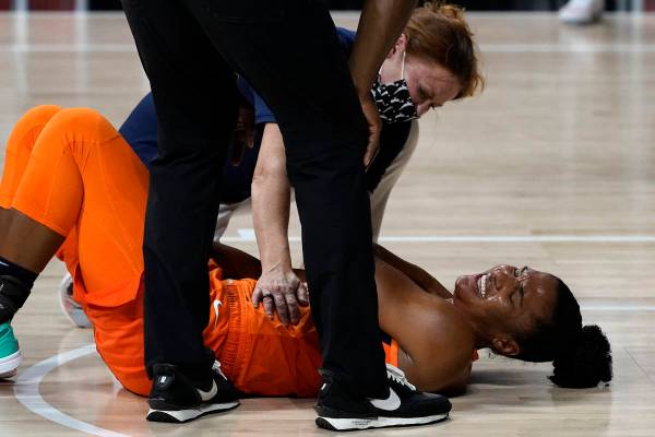 Un entrenador ayuda a Alyssa Thomas (25) del Connecticut Sun después de que se lesionara en la ...