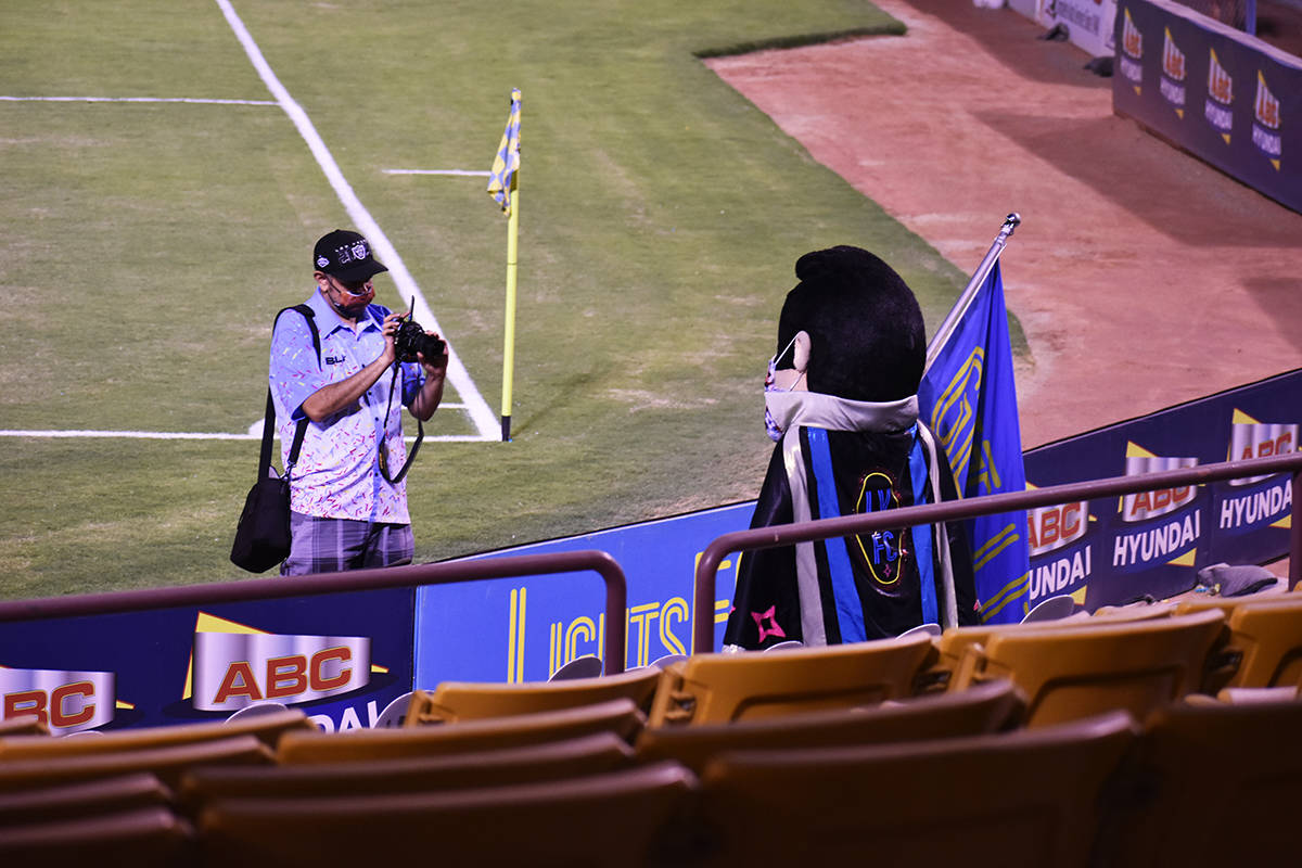 Harry Ruiz le da instrucciones a la mascota de Las Vegas Lights FC, "Cash", para poder fotograf ...