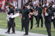 El entrenador de los Raiders de Las Vegas, Jon Gruden, centro, reacciona mientras los árbitros ...
