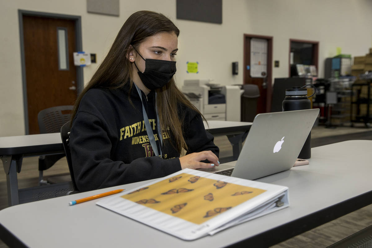 La estudiante Tatum Bowers estudia en la biblioteca con un cubrebocas y manteniendo su distanci ...