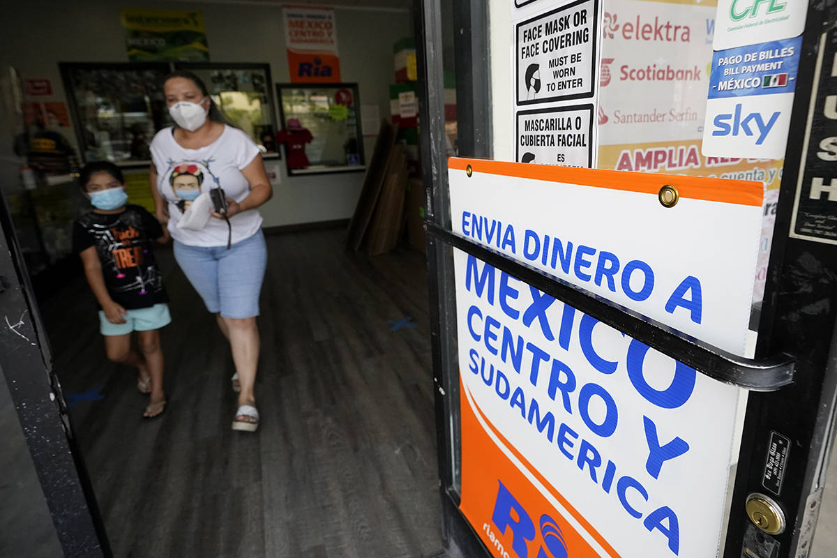 Una mujer sale de una tienda que ofrece servicios para enviar remesas a México y Centroaméric ...
