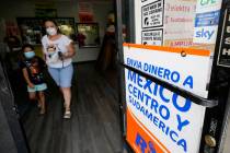 Una mujer sale de una tienda que ofrece servicios para enviar remesas a México y Centroaméric ...