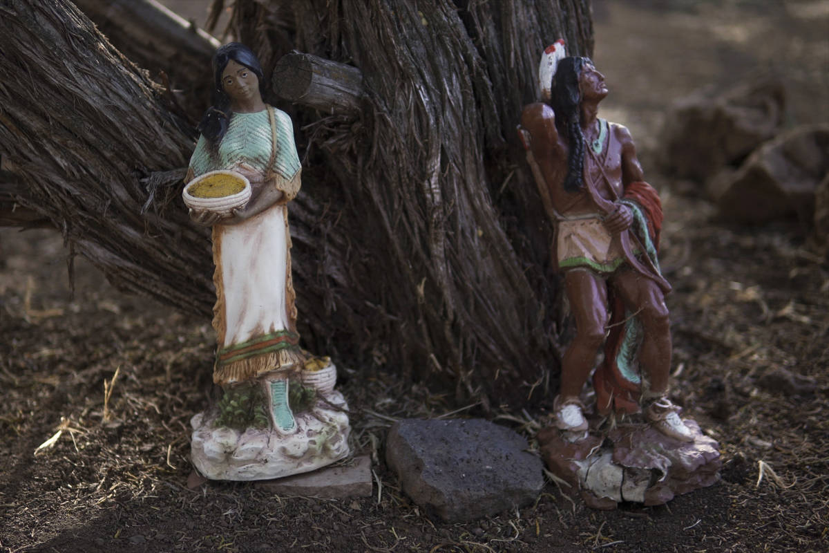 Estatuas indígenas decorativas se alinean en los árboles del patio trasero de Jeneda Benally ...