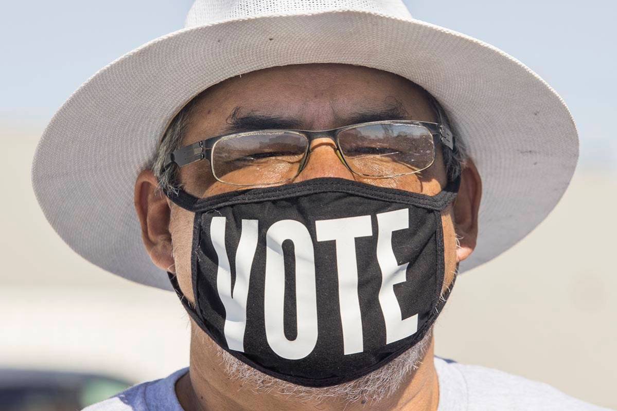 Eddie Ramos lleva un cubrebocas con la palabra "vota" antes de que la candidata demócrata a la ...