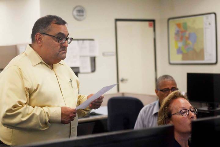 Joe Gloria, el registrador de votantes del condado, mira por encima de los hombros de la superv ...