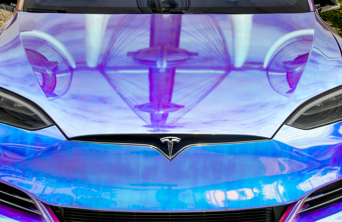 The High Roller se refleja en el cofre de un Tesla estacionado en la estación de supercarga de ...